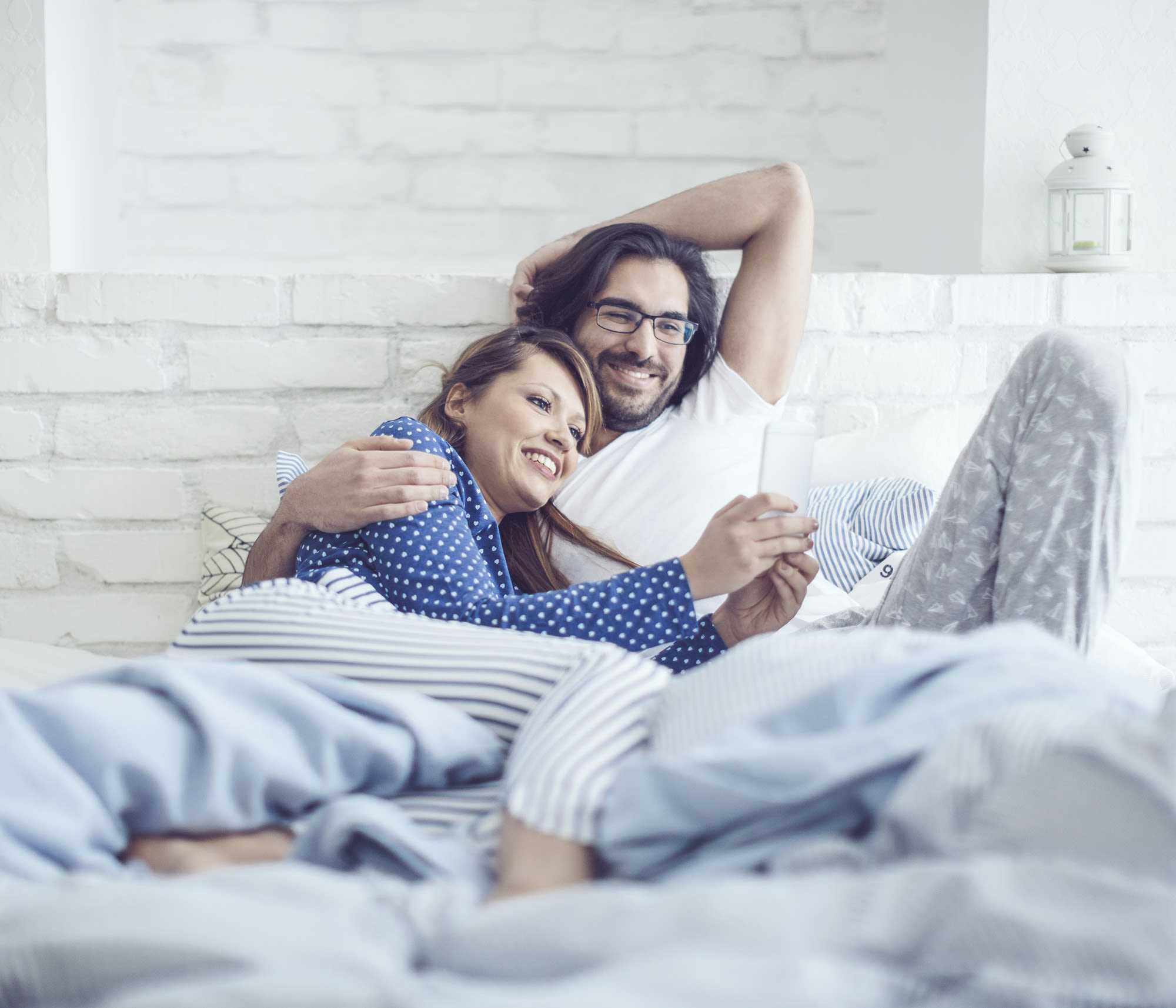 man and woman on phone in bedroom researching Carrier HVAC systems