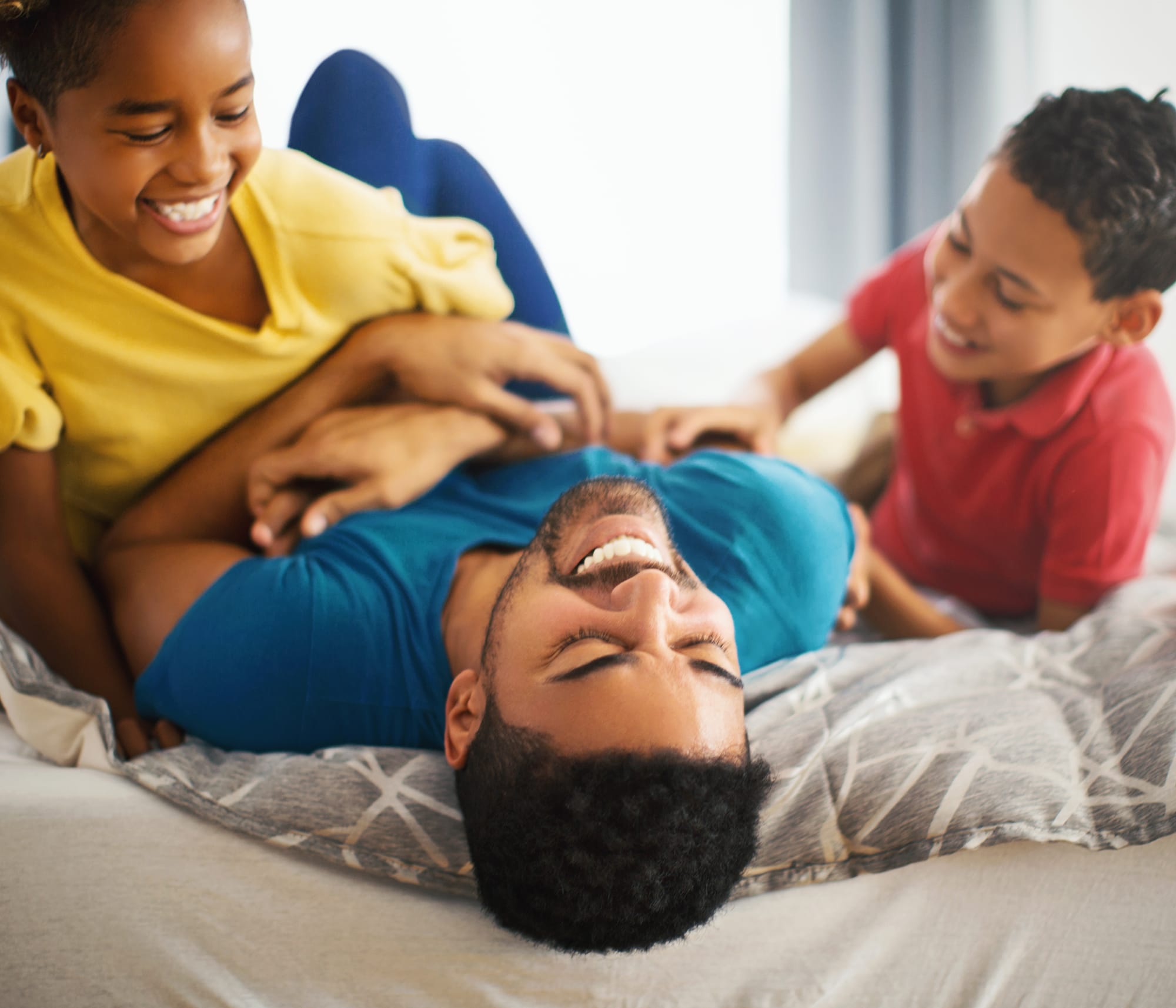 father-with-two-kids-on-bed