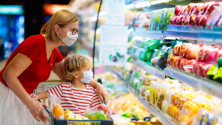 Woman looking at refrigerated produce in supermarket