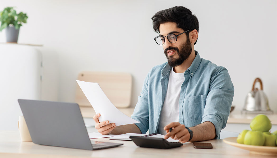 man-reading-and-using-calculator-1168x666