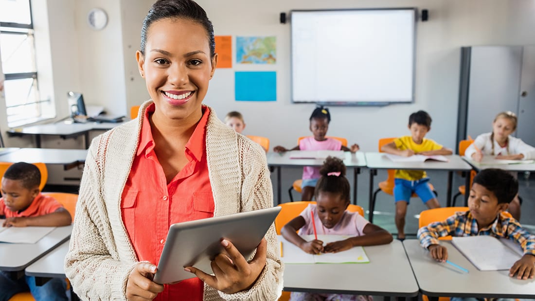 teacher-in-classroom-with-tablet