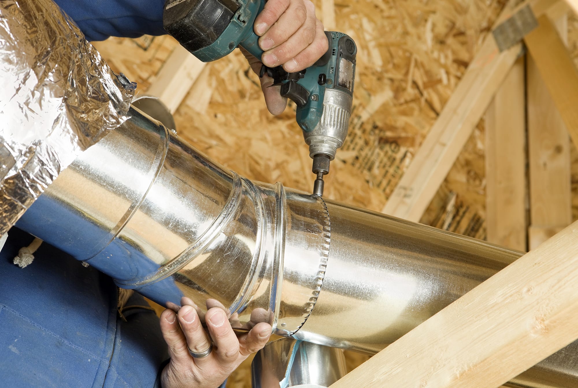 dealer-using-drill-to-install-ductwork