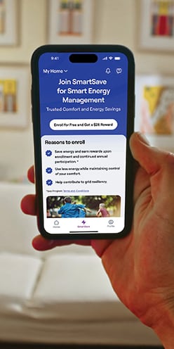 person-holding-a-phone-showing-the-carrier-smartsave-app-mb