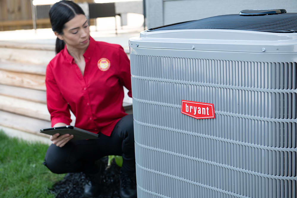 bryant-dealer-inspects-ac-system-outside-home