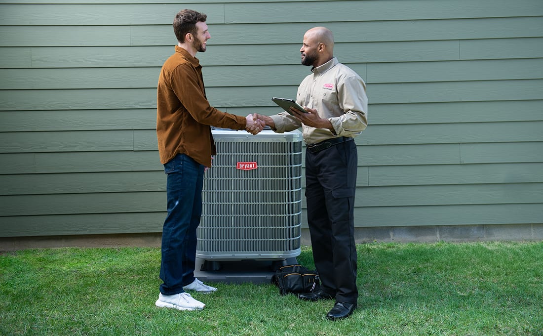 bryant-dealer-discusses-hvac-parts-needed-with-homeowner-by-ac-unit