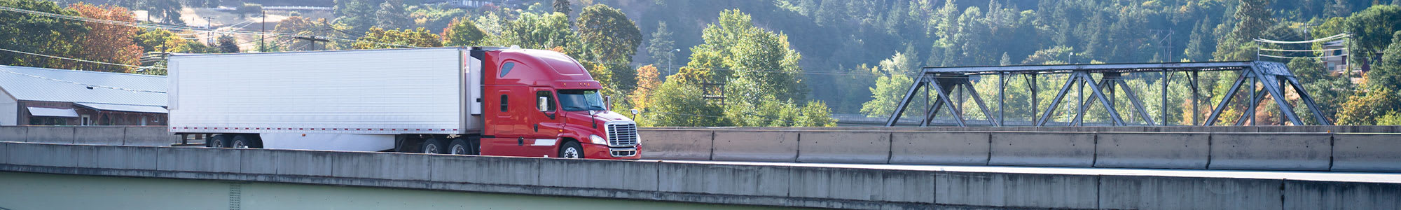 Red Refrigerated Trailer Crossing Bridge