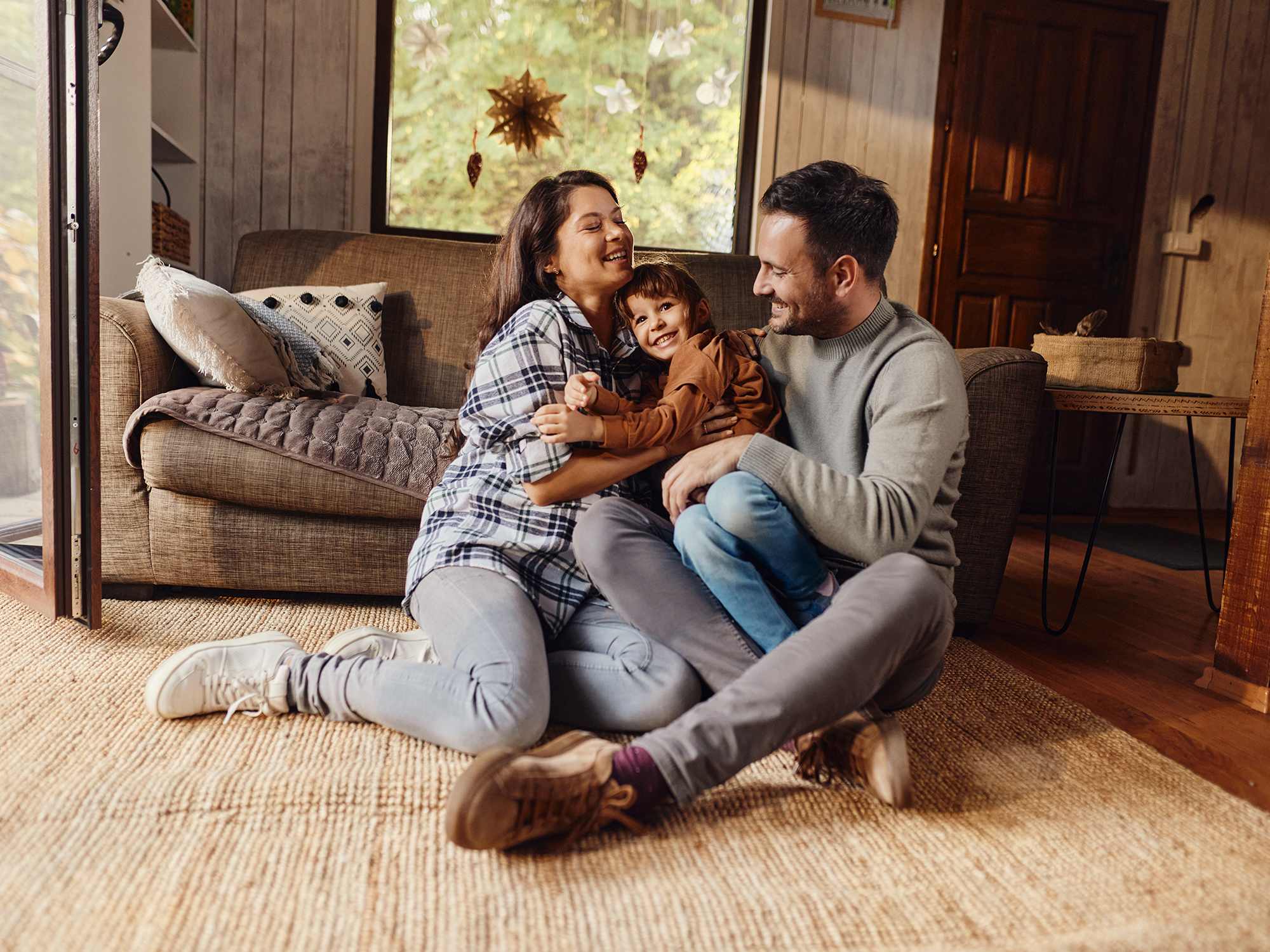 family-sitting-on-the-floor-in-front-of-grey-couch
