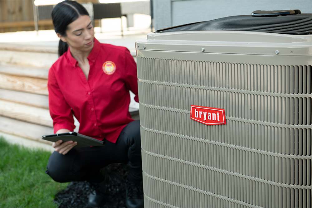 bryant-dealer-inspects-ac-system-outside-home