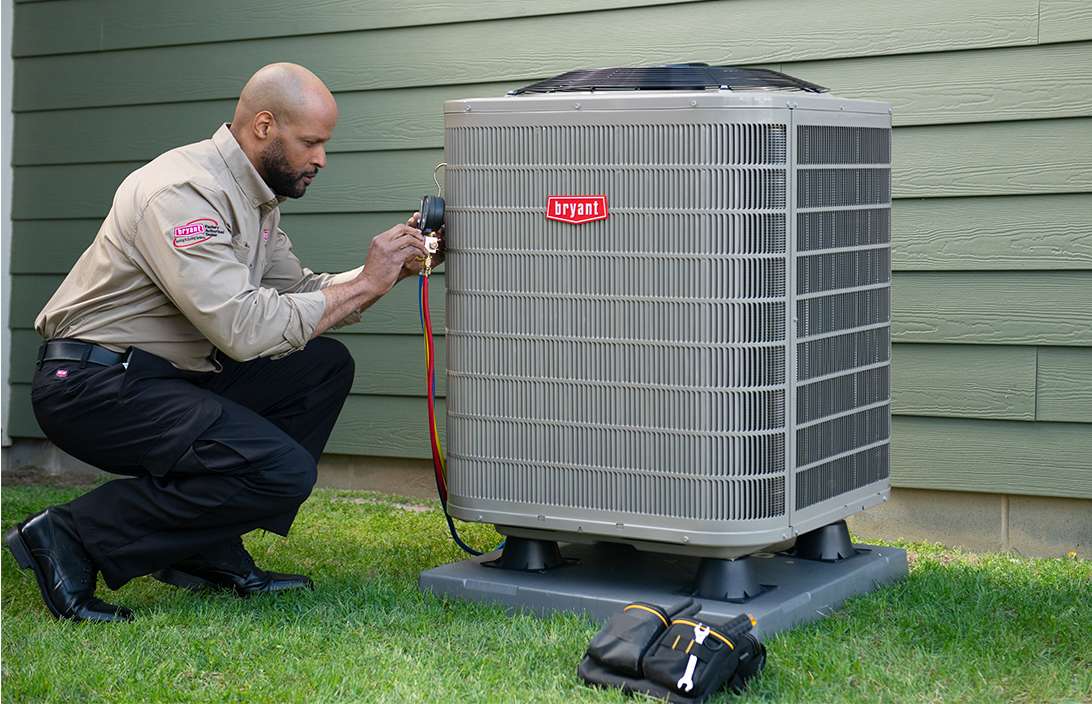bryant-dealer-inspects-air-conditioning-unit-outside-home