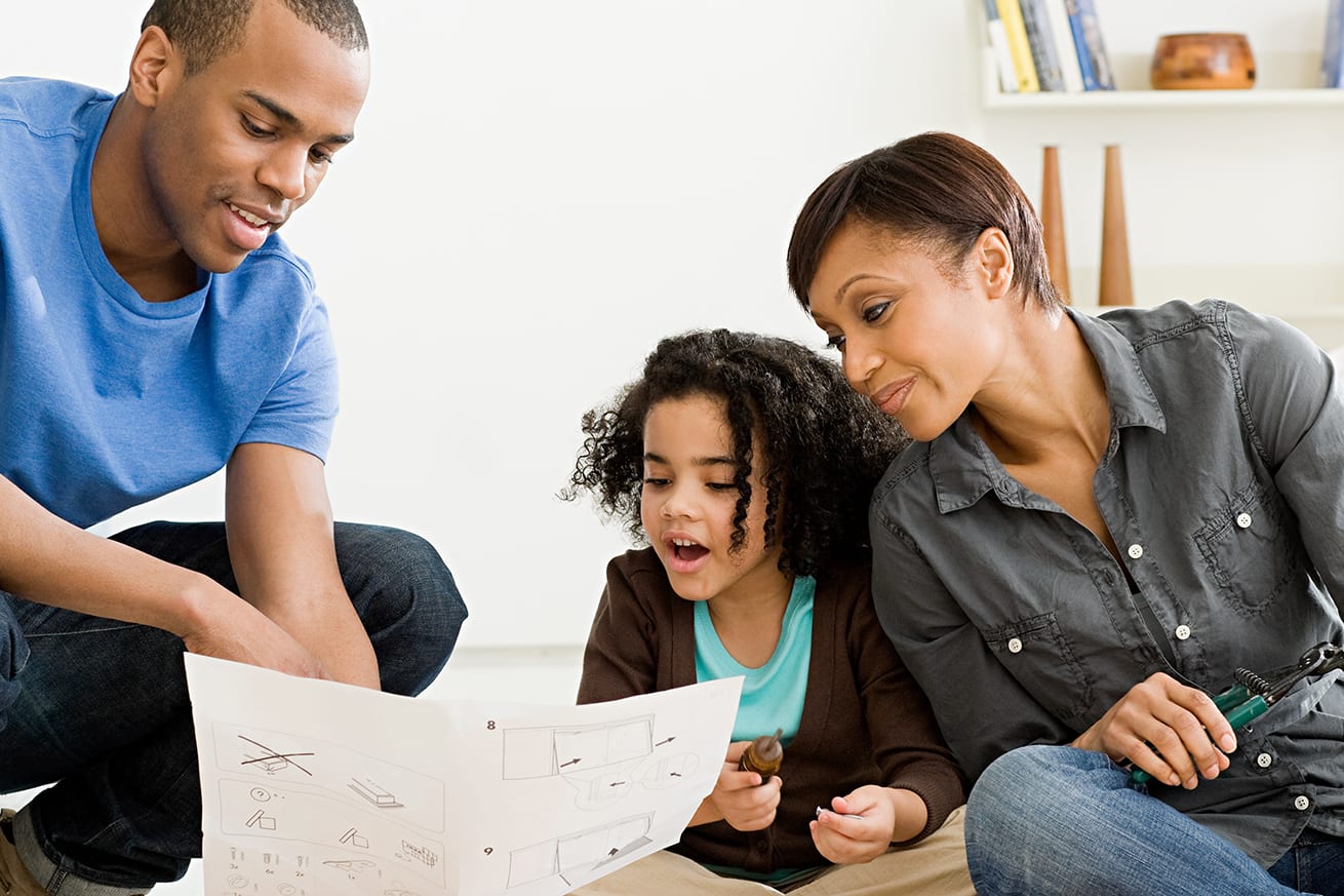 three-person-family-looking-at-house-information-3x2