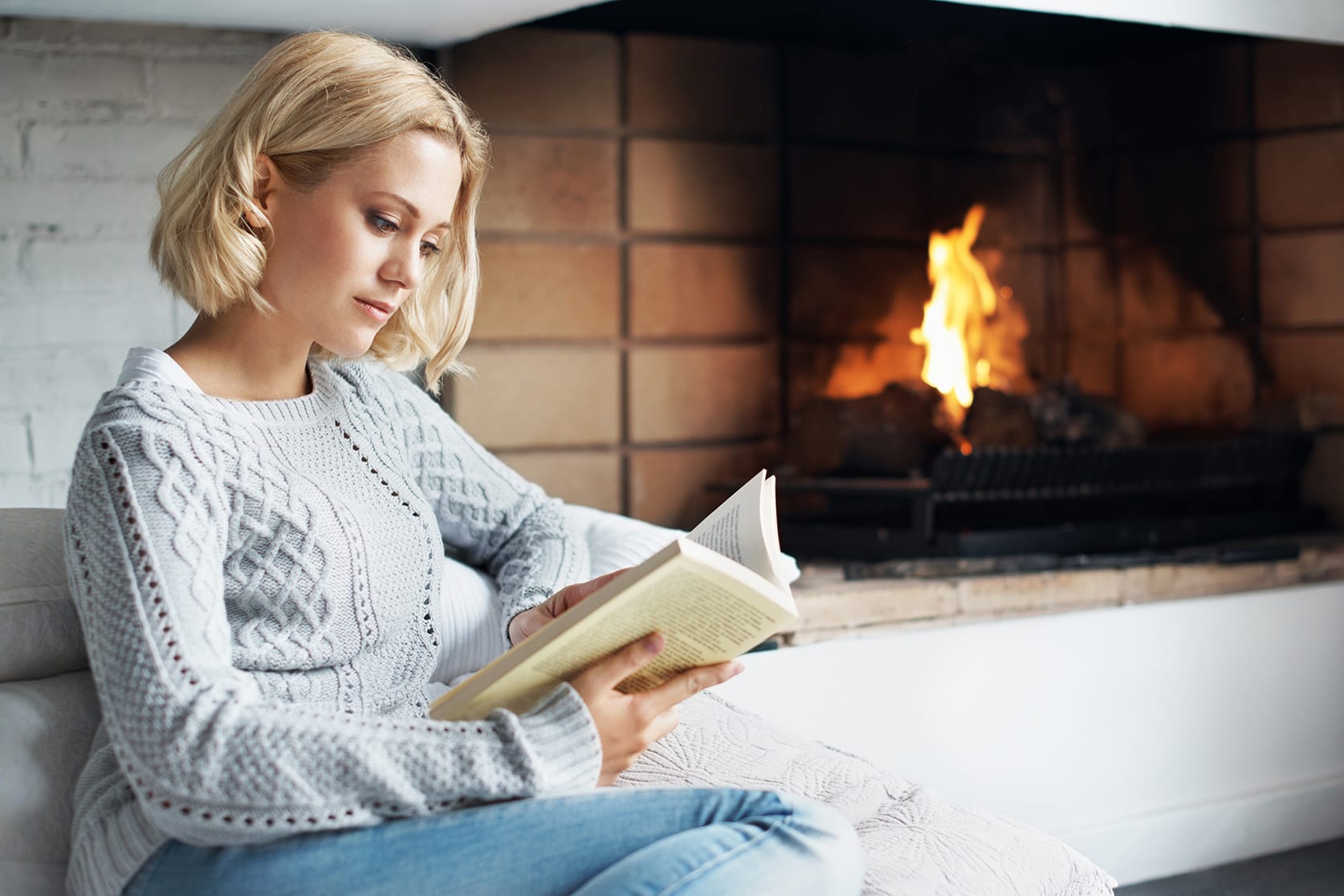 woman-sitting-by-fireplace-reading-3x2