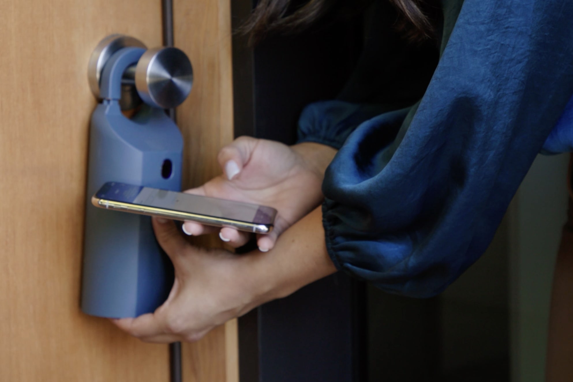 Real estate agent using mobile app to open lockbox on home for sale.