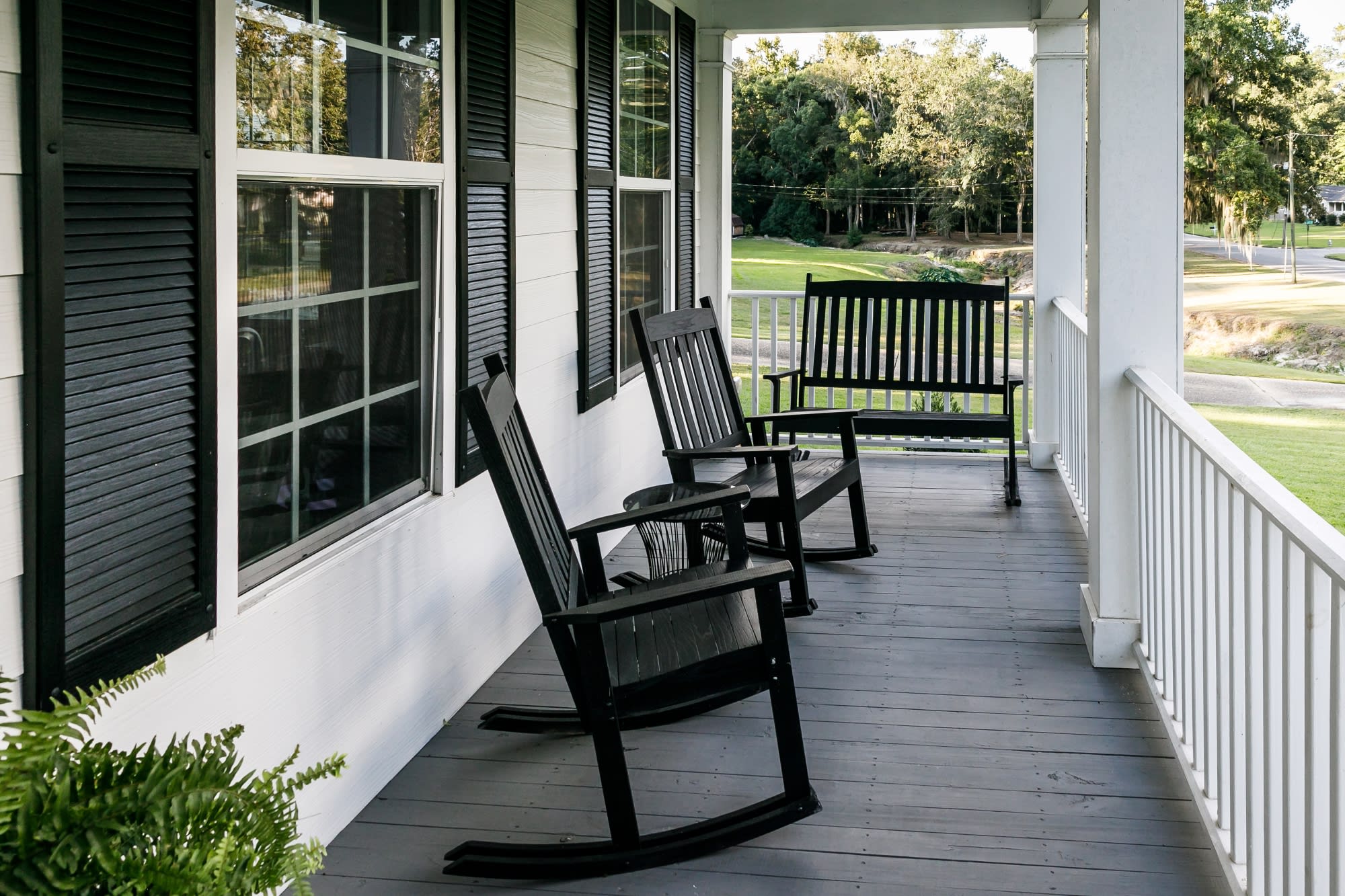 Side view of front porch with rocking chairs and bench