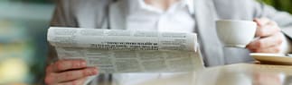 person-reading-newspaper-with-tea-cup-1x4