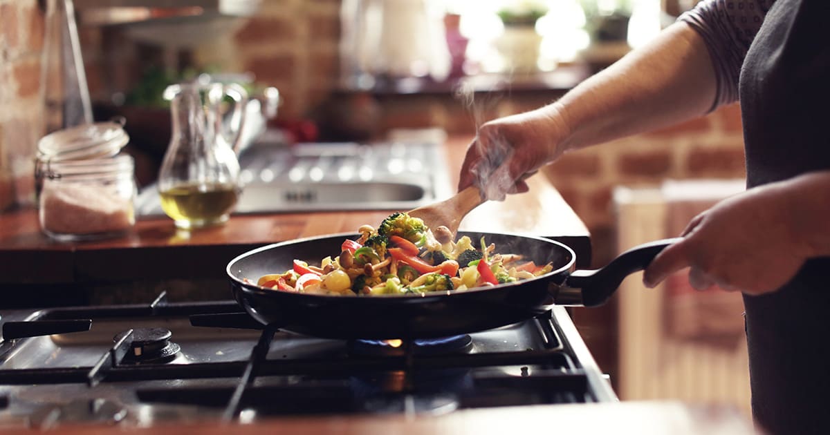 woman-cooking-on-gas-stove-which-is-a-source-of-carbon-monixide