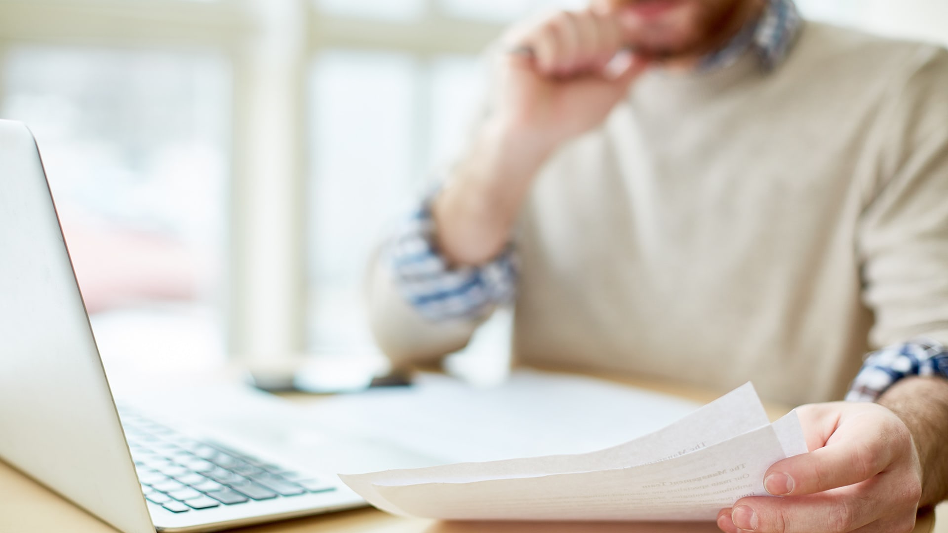 man-at-computer-with-paper