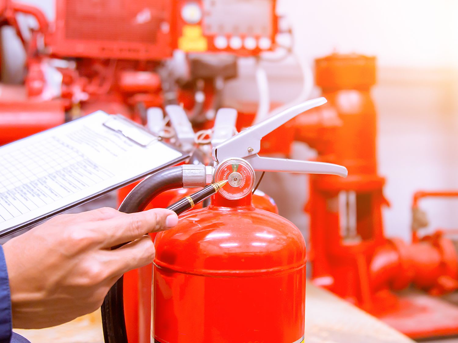 technician-clipboard-checking-fire-extinguisher-pressure_4-3