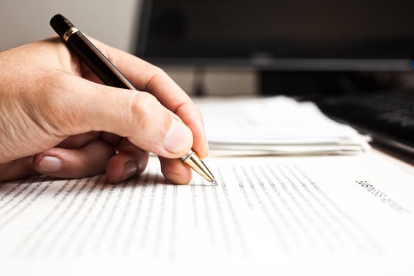 carrier-person-writing-on-document-with-pen