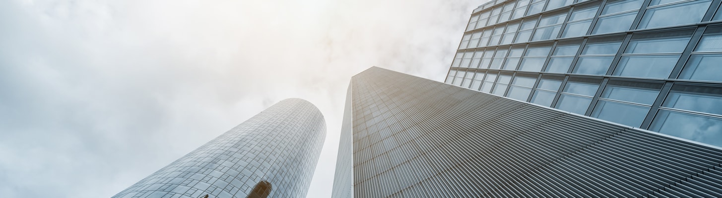 tall-office-buildings-looking-up-clouds_c
