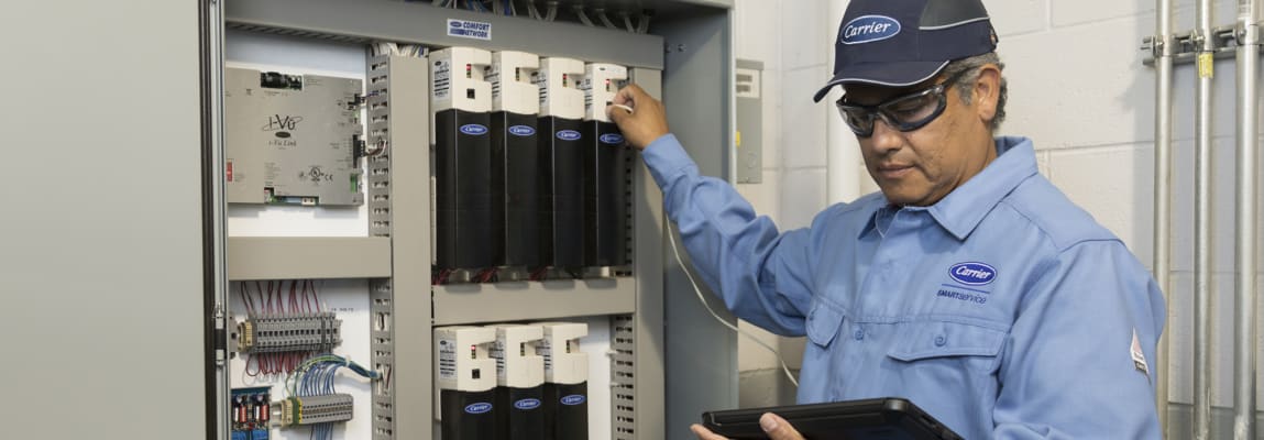 carrier-service-technician-in-equipment-room-servicing-panel-crop