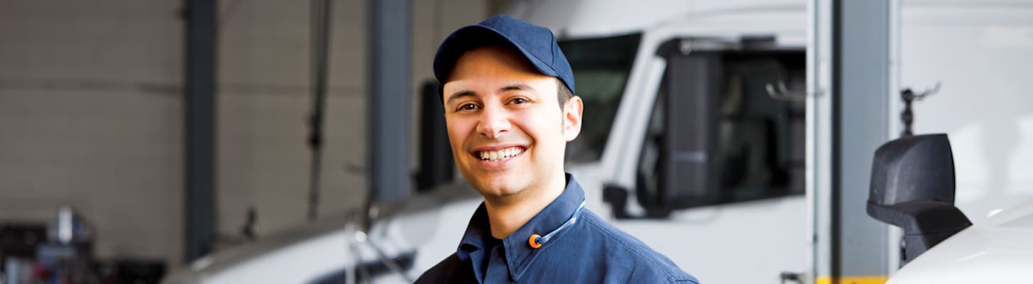 service technician with trucks inside garage