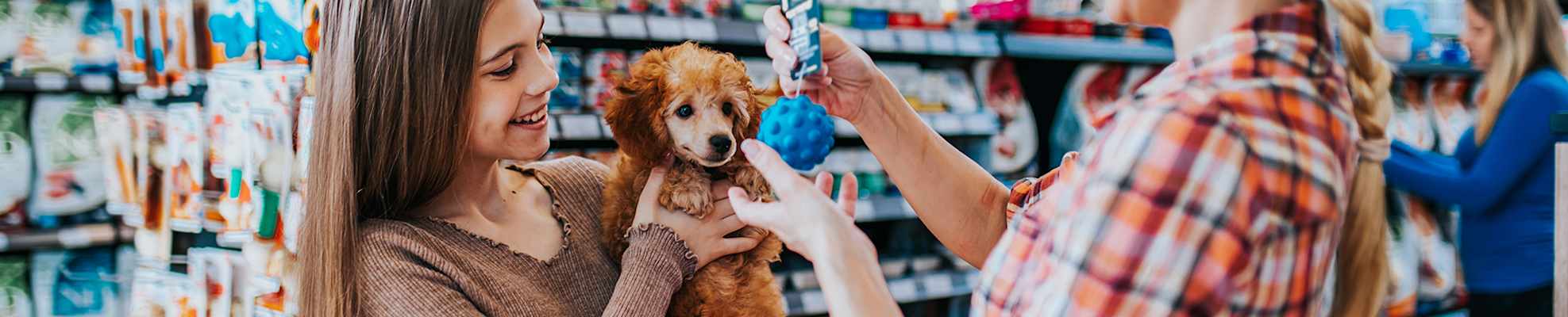 woman-girl-with-puppy-in-store-2000x400