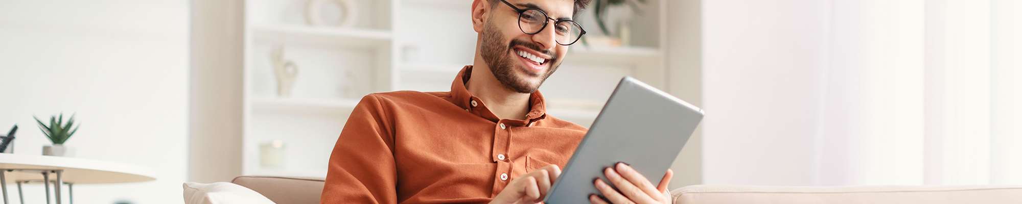 man-on-couch-with-tablet-2000x400