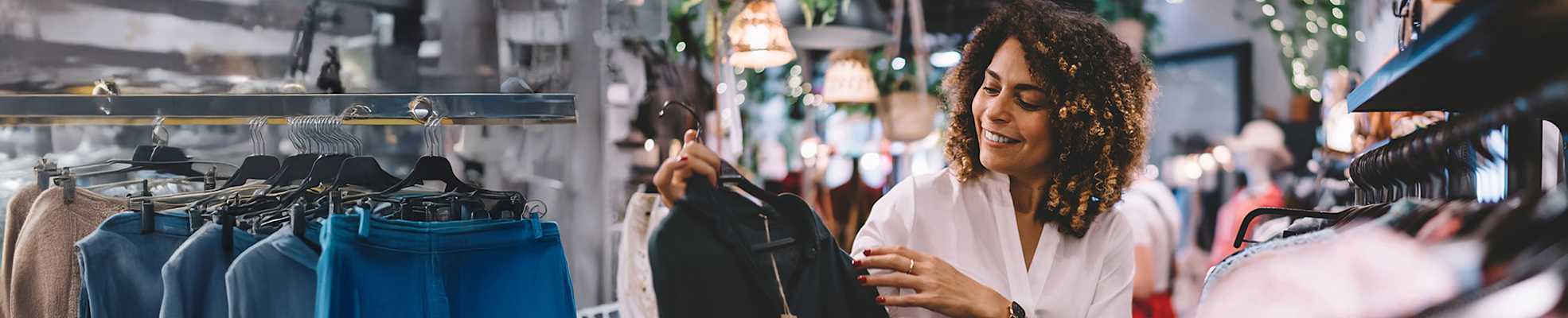 woman-in-retail-store-looking-at-clothes-2000x400