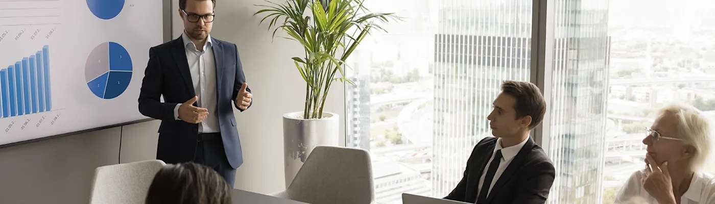 man-talking-to-group-in-conference-room-2000x400