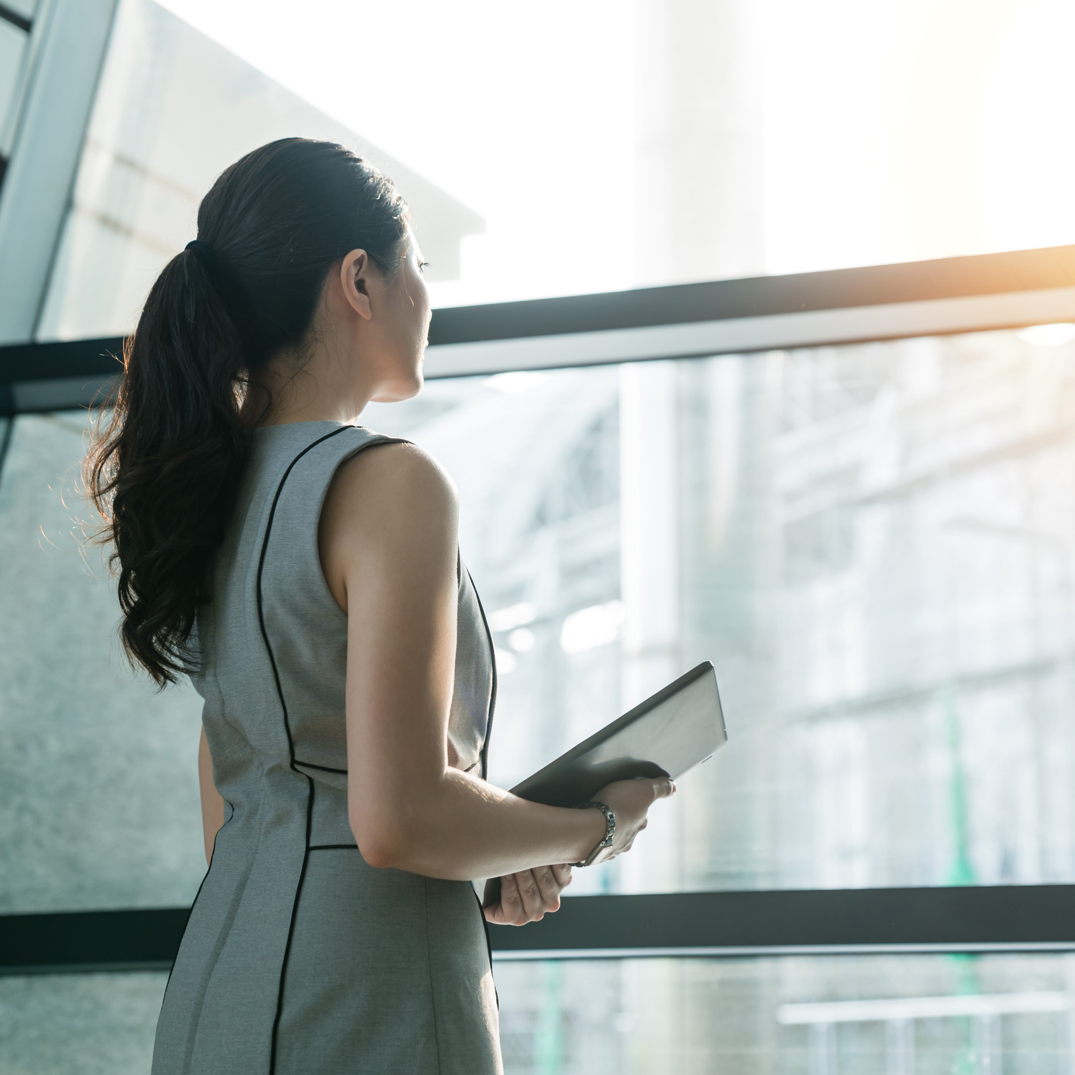 woman-looking-out-office-window-1x1