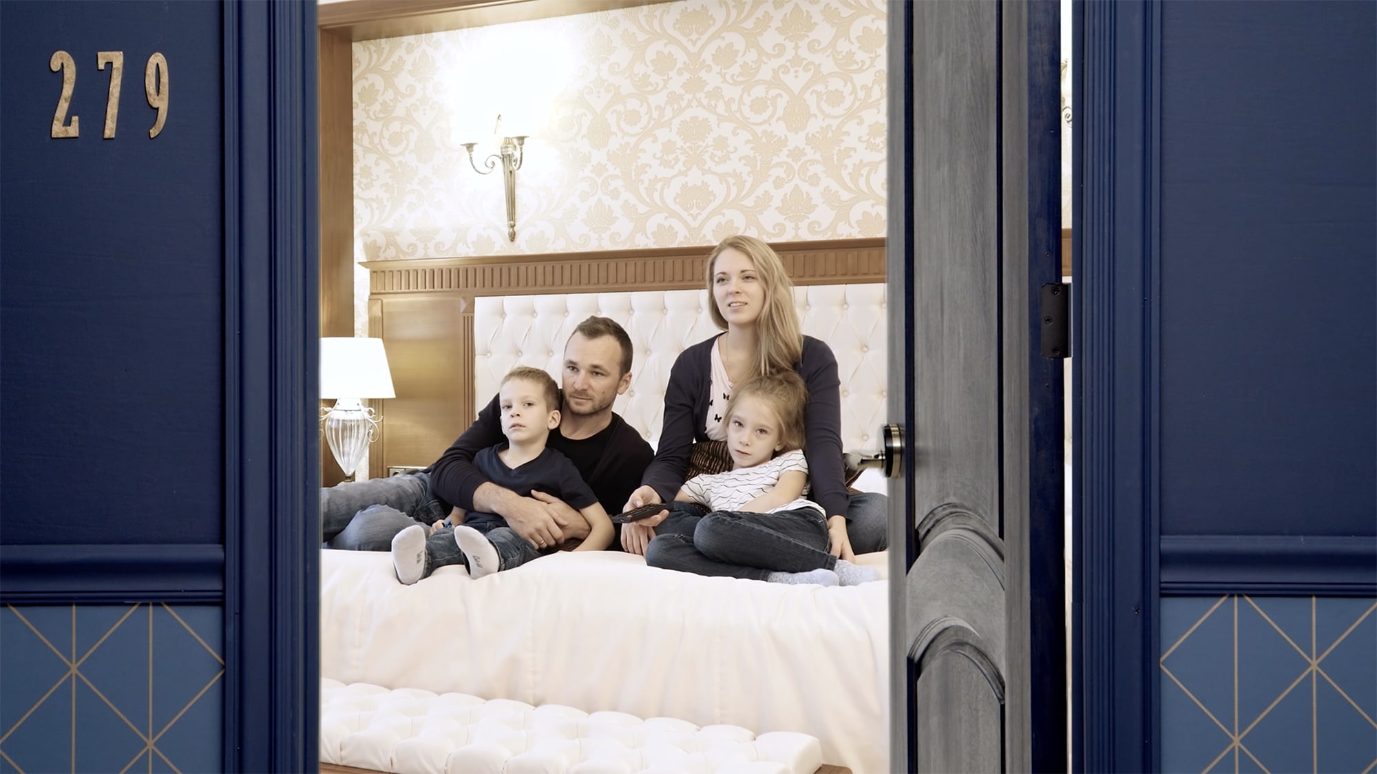 family-in-hotel-room-watching-tv-16x9