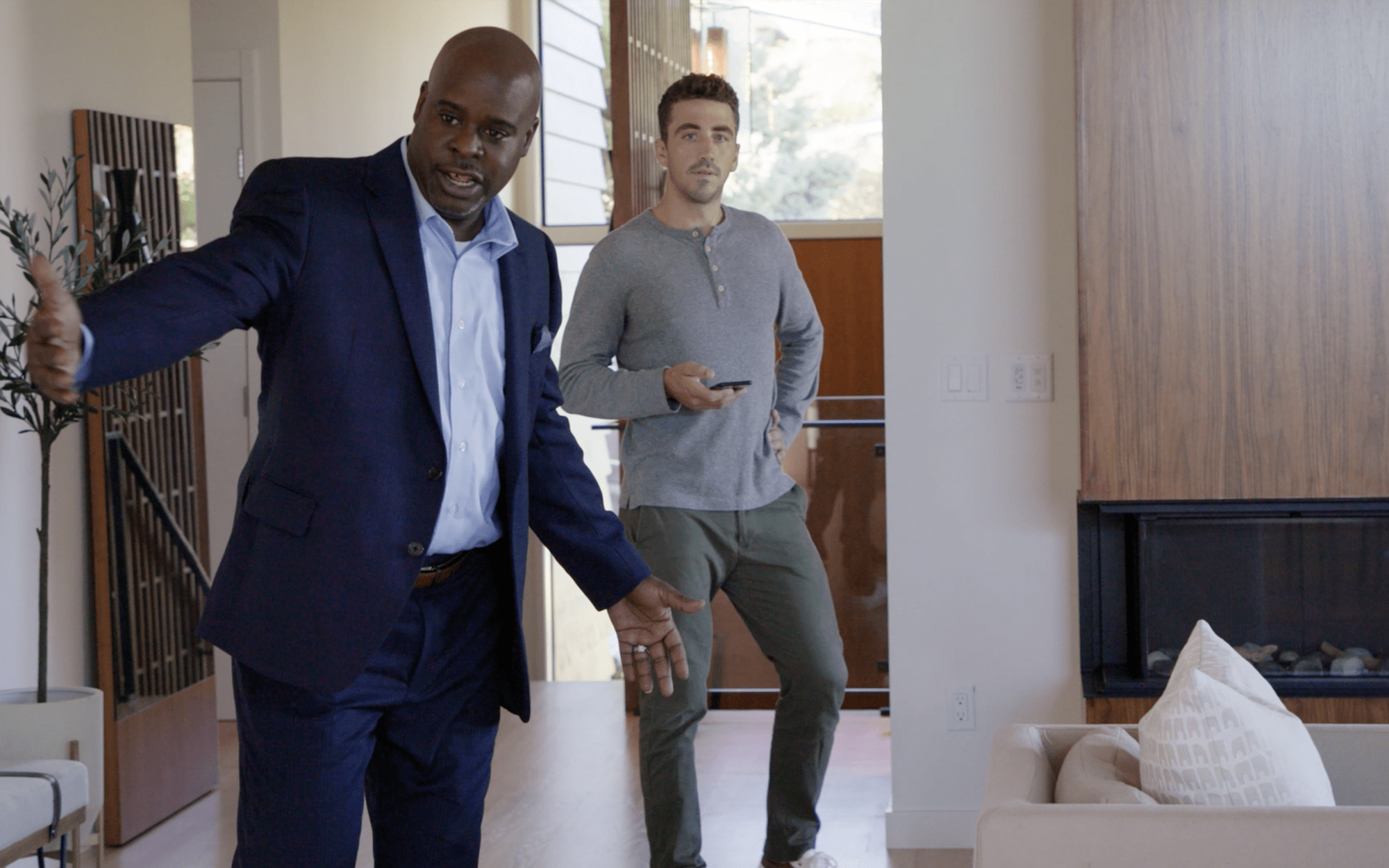 Real estate agent showing house to adult male in entryway