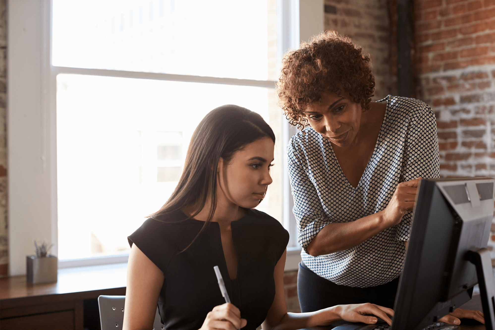 Two business women working at a computer