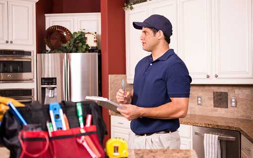 Male contractor with clipboard in kitchen