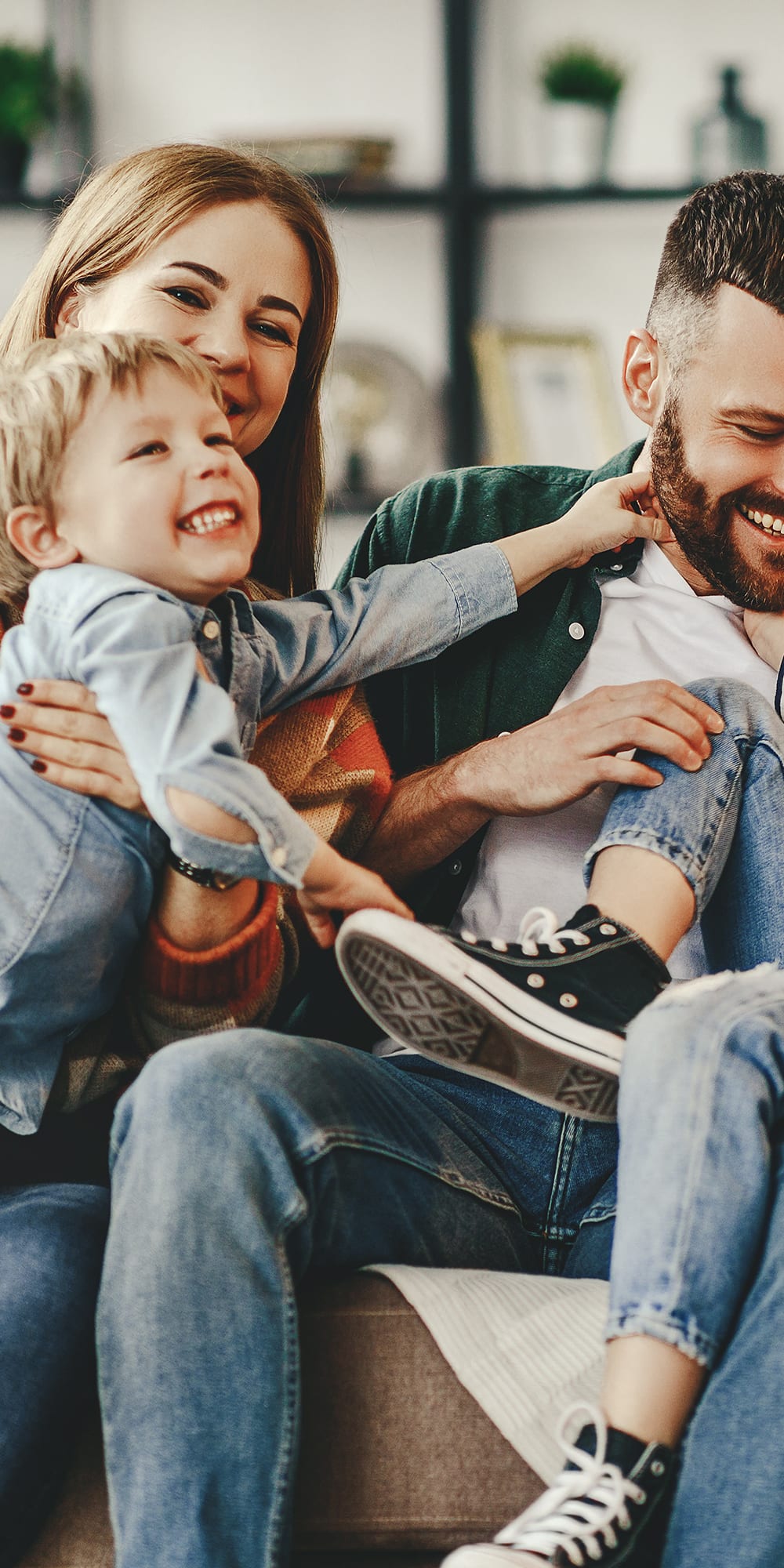 happy-family-mother-father-and-kids-at-home-on-couch-1x2