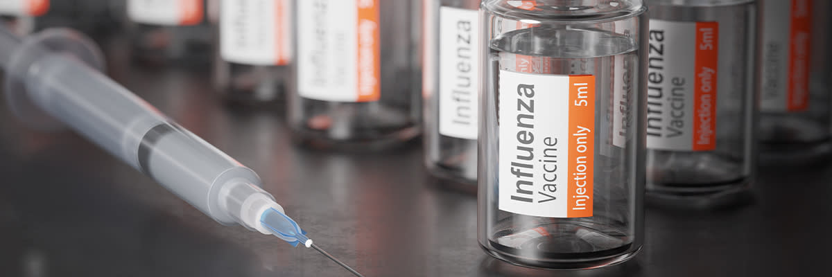 closeup of flu vaccine vials with syringe
